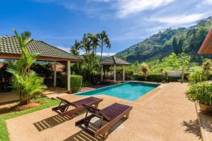 una piscina con dos sillas y una mesa en Aster Pool Villa, en Rawai Beach