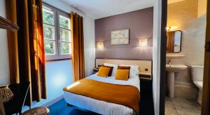 a bedroom with a bed and a sink and a toilet at L'Escoundillou in Saint-Jacques-des-Blats