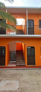 un bâtiment orange avec des escaliers en face de celui-ci dans l'établissement cuartos en renta El portón azul, à Ixtepec