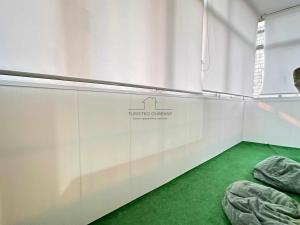 a room with white walls and green carpet at O fogar da nube in Ourense