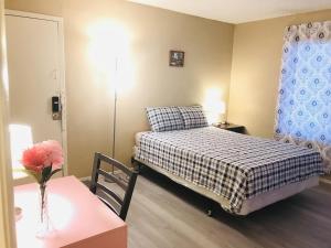 a bedroom with a bed and a table with a vase of flowers at Independent bedroom with private bathroom#2 in Las Vegas