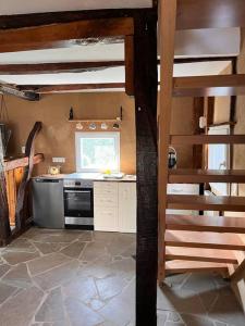 a kitchen with a stove and a spiral staircase at Wohnen auf dem Bauernhof in Herdecke