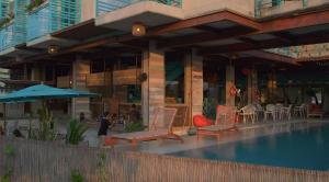 un edificio con sillas, mesas y una piscina en MuchoSur Manzanillo CTG en Cartagena de Indias