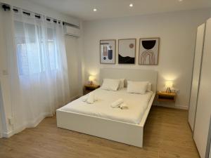 una camera con un letto bianco con due comodini di Apartamento Dúplex de Lujo con Terraza y vistas al Castillo - Centro a Xàtiva