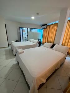 a hotel room with two beds in a room at BRYSS HOTEL in Santo Domingo de los Colorados