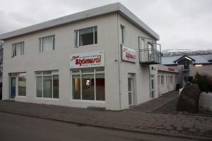 um edifício branco com um sinal para uma loja em AK Apartments em Akureyri