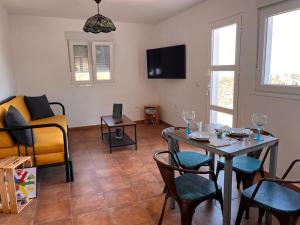 ein Wohnzimmer mit einem Tisch und Stühlen sowie einem TV in der Unterkunft Casa Valentina El Hierro in Frontera