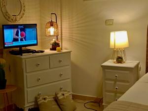 a bedroom with a dresser with a television and a lamp at Casa IL Tempio in Syracuse