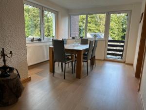 a dining room with a table and chairs and windows at Ferienwohnungen Medikus in Luftkurort Lückendorf