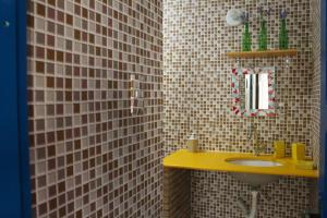 uma casa de banho com um lavatório amarelo e um espelho. em Tamboleiro's Hotel Residence em Salvador