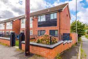 a brick house with a flower box in front of it at Stylish 3 Bedroom home close to Manchester City centre in Oldham
