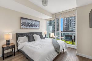 a bedroom with a bed and a large window at Ultra Luxurious 2.5 Bedroom 2 Full Bathroom 1 Parking Condo Near SQ1 Striking Views in Mississauga +77 photos