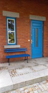 a blue bench next to a building with a blue door at U Janciów in Kraków
