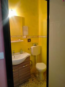 Baño amarillo con aseo y lavamanos en Casamuseo del Risorgimento, en Lungro