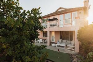 Luxe Boho Retreat Near Torrey Pines - Sleeps 10 في سان دييغو: منزل كبير مع أريكة في الفناء
