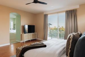 Luxe Boho Retreat Near Torrey Pines - Sleeps 10 في سان دييغو: غرفة نوم بسرير وتلفزيون وشرفة