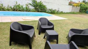 El Escaparate في La Chacarita: أربعة كراسي سوداء وطاولة بجانب مسبح