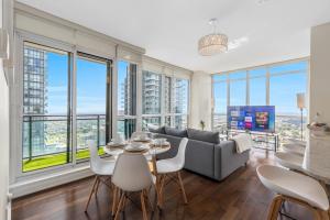 een woonkamer met een bank en een tafel en stoelen bij Ultra Luxurious 2.5 Bedroom 2 Full Bathroom 1 Parking Condo Near SQ1 Striking Views in Mississauga