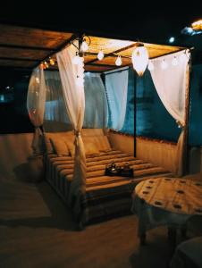 łóżko w namiocie z lampkami i zasłonami w obiekcie Dar SBAA w mieście Szafszawan