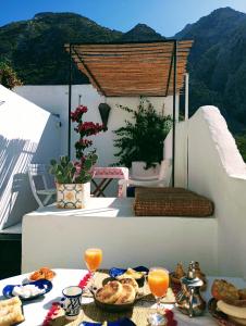 - une table avec de la nourriture et des boissons sur un balcon dans l'établissement Dar SBAA, à Chefchaouen