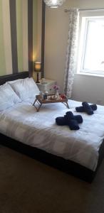 Un dormitorio con una cama con una mesa. en Beautiful family getaway, close to the beach, en Fairbourne