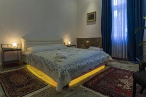 a bedroom with a large bed with blue curtains at E&E Apartments in Ljubljana