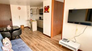 ein Wohnzimmer mit einem Sofa und einem Tisch sowie eine Küche in der Unterkunft Av santander Apartaestudio premium in Manizales