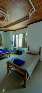 1 dormitorio con 1 cama grande y techo de madera en Bamboo Garden Tourist Inn, en Carmen