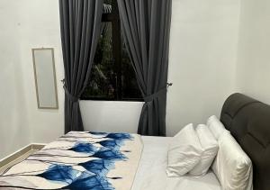 - une chambre dotée d'un lit avec une couverture bleue et blanche dans l'établissement Homestay Durian Belanda, à Jertih