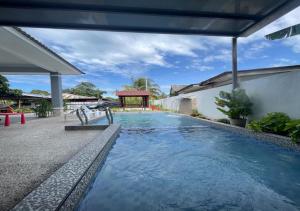 - une piscine d'eau bleue dans une maison dans l'établissement Homestay Durian Belanda, à Jertih