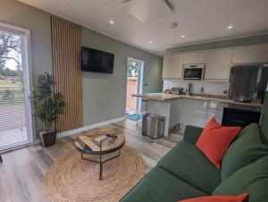 a living room with a green couch and a table at Gosling Lodge in Durham