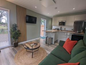 a living room with a green couch and a table at Gosling Lodge in Durham +15 photos