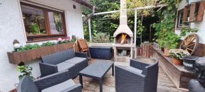 eine Terrasse mit einem Kamin, Stühlen und einer Feuerstelle in der Unterkunft Ferienwohnung Casa Alotto in Windeck