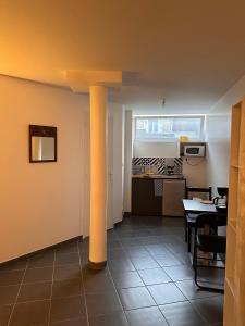 een woonkamer met een tafel en een keuken bij Un studio dans la résidence SJT in Alençon