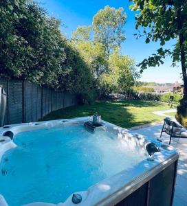 una bañera de hidromasaje en el patio trasero de un patio en Luxury Goodwood home, Hot tub, 3 Bedrooms, Pet Friendly, en Chichester