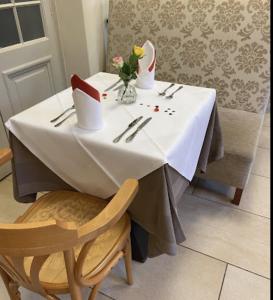 a table with a white tablecloth and a vase of flowers on it at Gemütliche 1 Zimmerwohnung in Sankt Radegund bei Graz