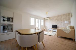 a kitchen and living room with a table and chairs at Maison, 4 personnes, wifi, terrasse, jardin, piscine partagée in Coulounieix-Chamiers +2 photos