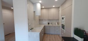 a kitchen with white cabinets and white appliances at Better Place Modern Port Praski in Warsaw