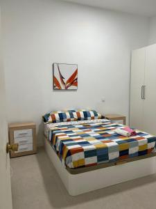 a bedroom with a bed and a painting on the wall at aparment la Elipa in Madrid
