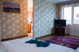 um quarto com uma cama e uma televisão de ecrã plano em Сити em Petropavl