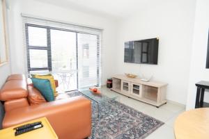 a living room with a couch and a table at Stylish Apartment in Fourways in Sandton