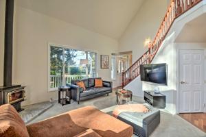 a living room with a couch and a tv at Fox Paws Luxury Cabin - Hot tub, Fire pit & Pines! in Hansville