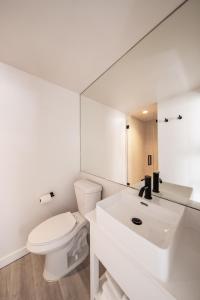 a white bathroom with a toilet and a sink at Casa Ocean in Miami Beach