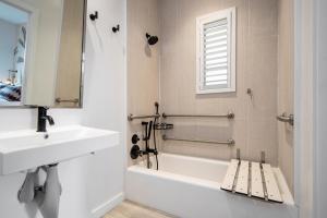 a white bathroom with a sink and a bath tub at Casa Ocean in Miami Beach