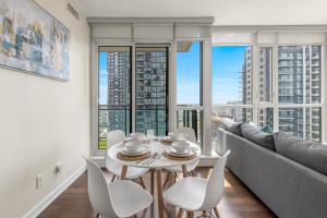 a dining room with a table and chairs and large windows at Ultra Luxurious 2.5 Bedroom 2 Full Bathroom 1 Parking Condo Near SQ1 Striking Views in Mississauga
