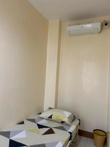 Cette petite chambre comprend un lit et un ventilateur. dans l'établissement JMC Residence 3, à Tagbilaran