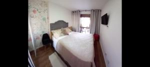 a small bedroom with a bed and a window at Apartamento Le Quartier - no centro, dois quartos, wi-fi, garagem, piscina, ar-condicionado, jacuzzi, sauna, etc in Juiz de Fora