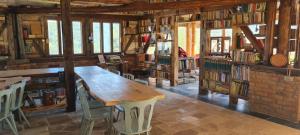 科德萊亞的住宿－Stana de carti，图书馆配有木桌、椅子和书籍