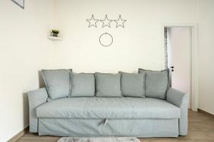a living room with a couch with four stars on the wall at Baracca Apartment in Massa Lombarda