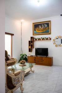 uma sala de estar com uma mesa e uma televisão em Homestay NJ Syariah : Pekalongan em Pekalongan